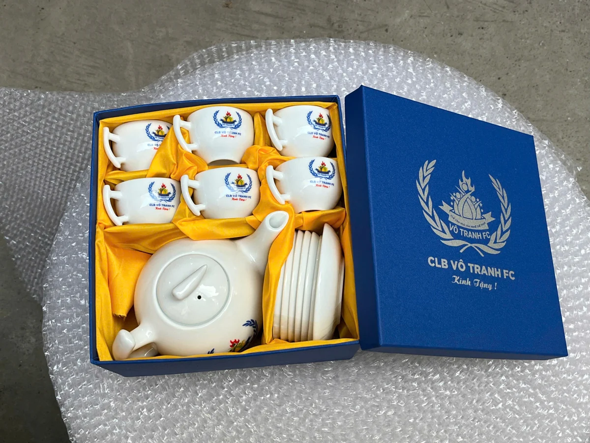 Bộ trà trắng trong hộp xanh lót vàng, nắp có nhận diện CLB Vỗ Tranh FC