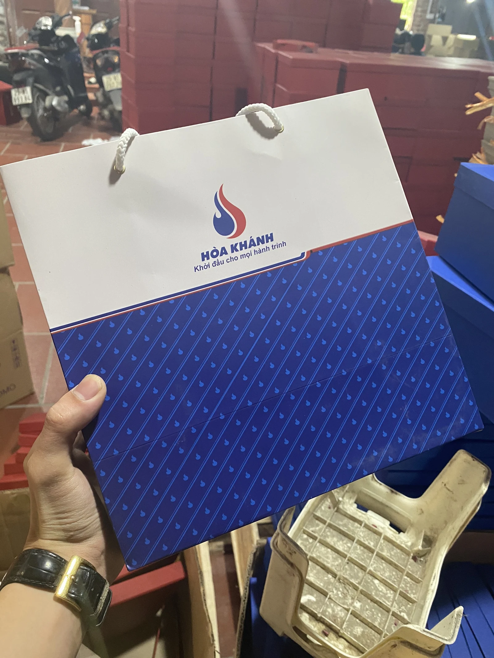 Túi giấy trắng xanh Hòa Khánh có quai dây được cầm lên