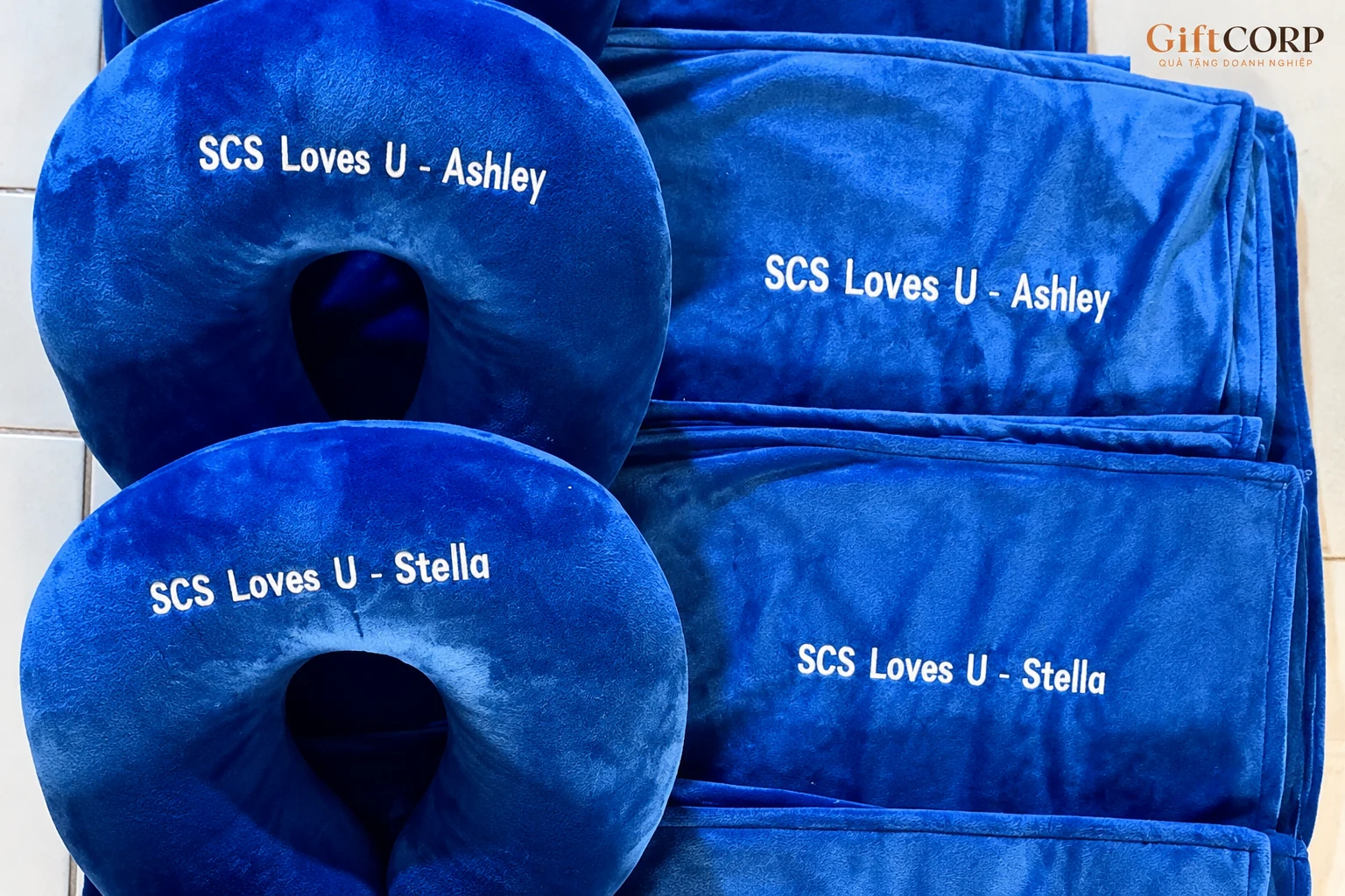 Góc cận hai cặp gối và phần vải xanh có tên Ashley và Stella