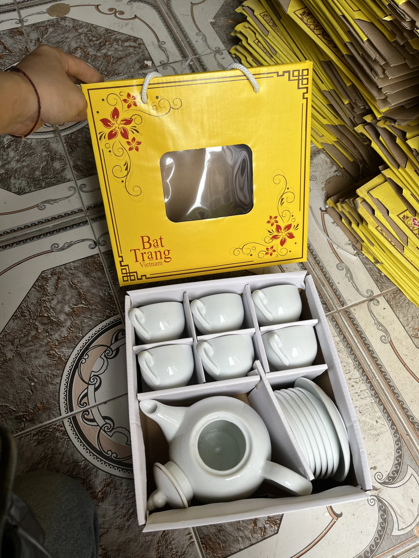 Bộ trà trắng trong hộp chia ngăn giấy, nắp hộp vàng cửa sổ có chữ Bat Trang Vietnam
