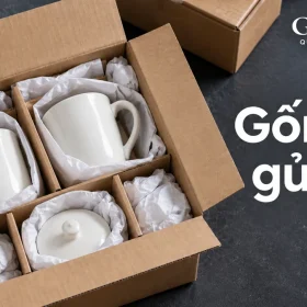 Cảnh dựng thùng carton có cốc trắng và nắp tách ngăn, chữ Gốm sứ gửi xa