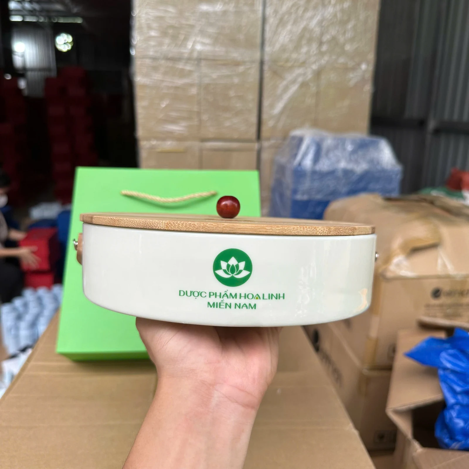 Hộp sứ trắng có nắp gỗ và hình xanh, cạnh túi đồng bộ