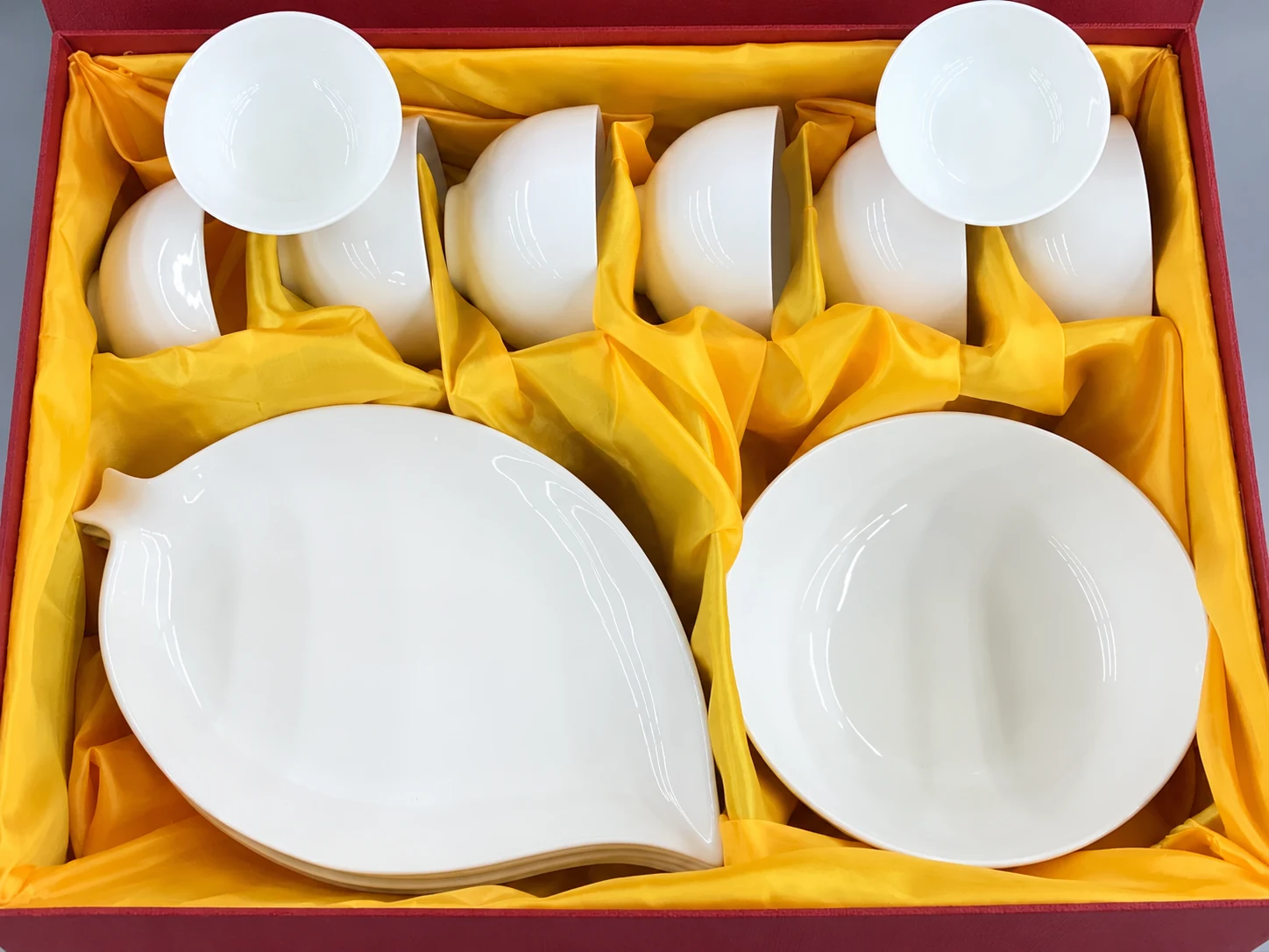 Góc cận các món sứ trắng và phần chia trong hộp đỏ