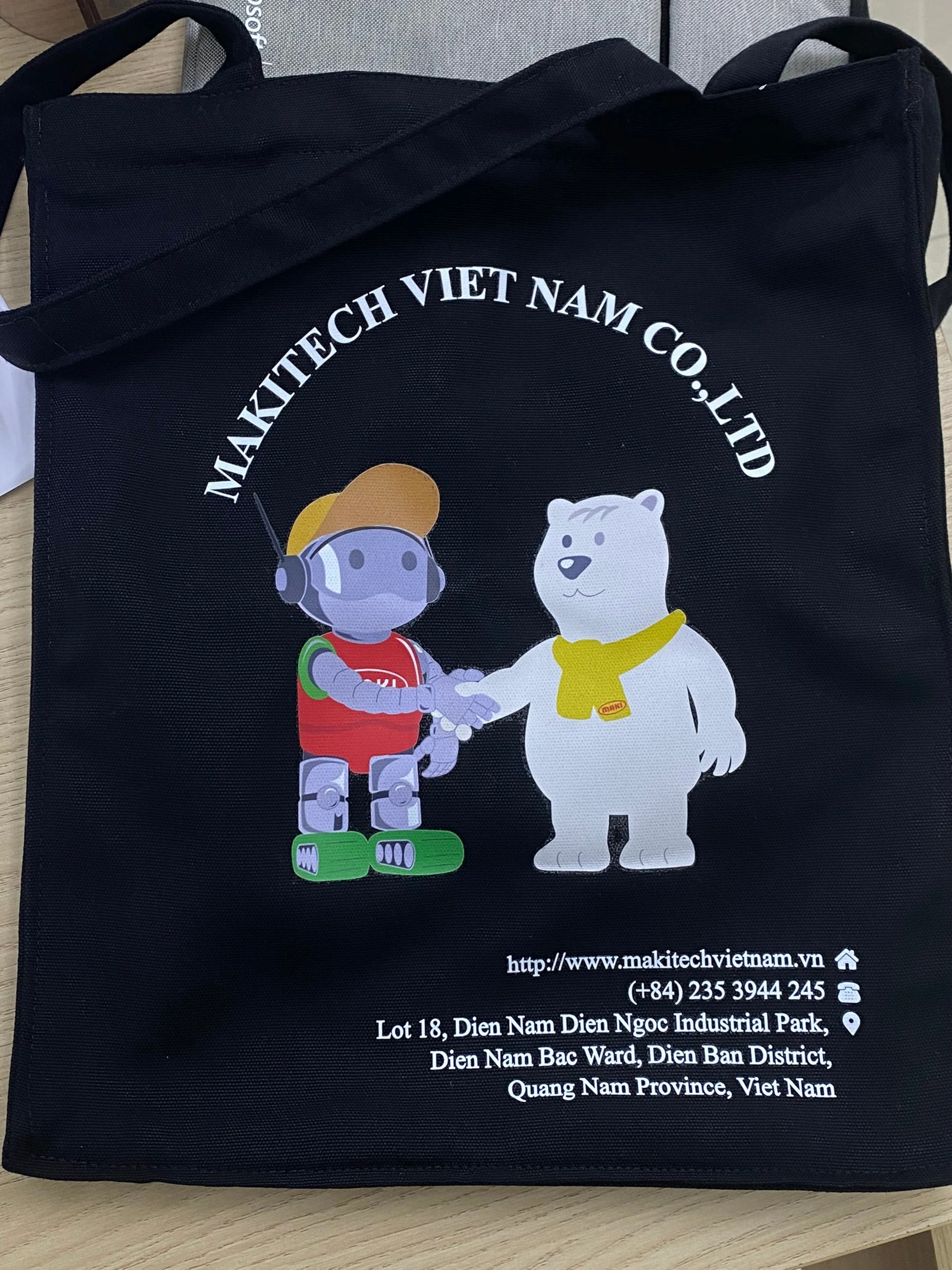 Ảnh chụp túi đen có tên MAKITECH VIET NAM màu trắng, hai nhân vật nhiều màu cùng thông tin nhỏ phía dưới
